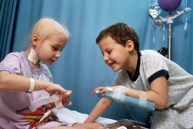 Children with cancer playing surrounded by treatment equipment