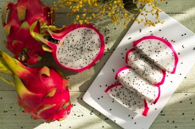 Full and sliced red-skinned dragon fruits/pitaya