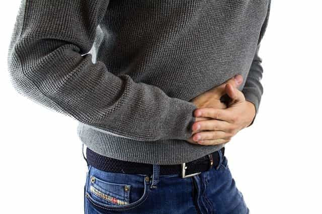 Man holding stomach due to abdominal pain