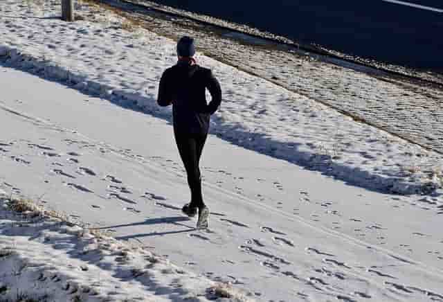 A person running on snow in the winter weather 