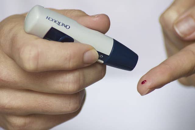 A person performing a finger-prick blood glucose test