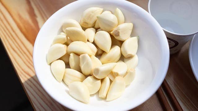 Garlic cloves in a small white bowl